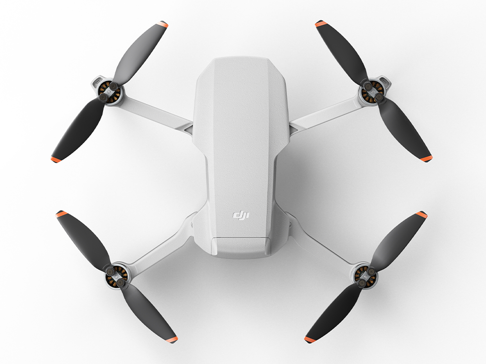 Un dron blanco desde arriba, con cuatro hélices. El dron está sobre un fondo blanco.