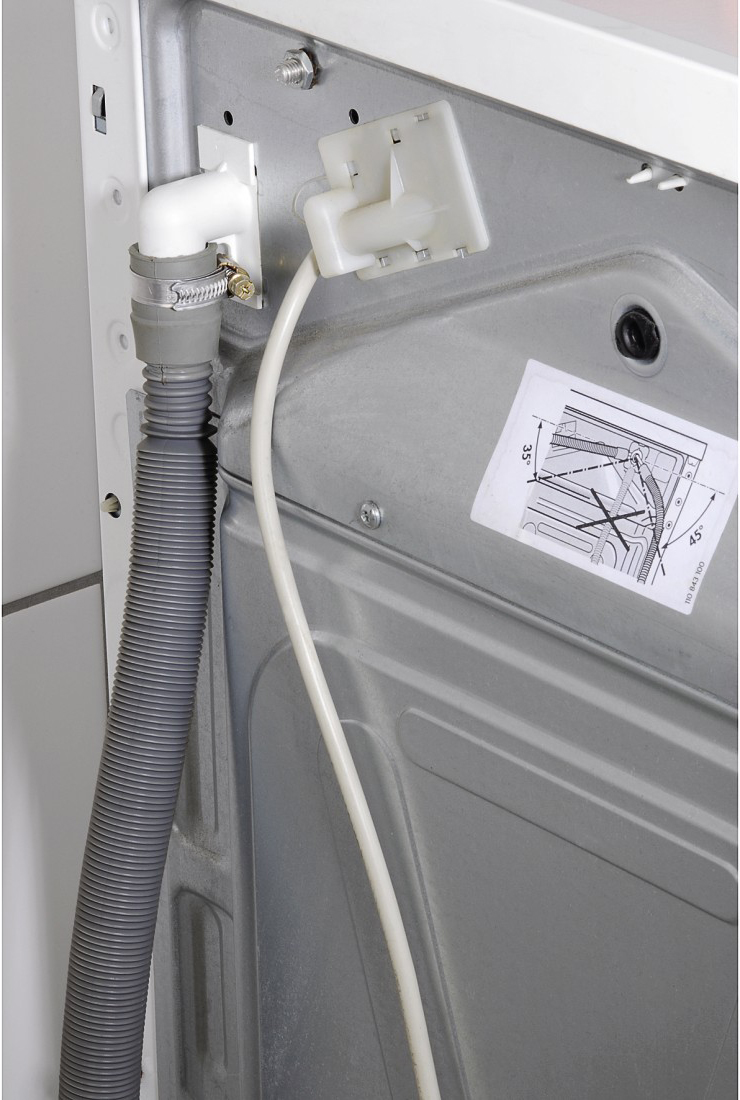 Back of a washing machine with hoses and connections visible. Grey and white colors.
