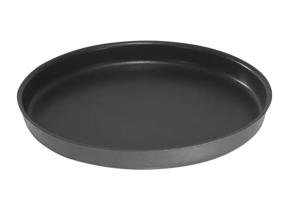Molde para hornear negro, redondo y ligeramente cóncavo sobre fondo blanco.