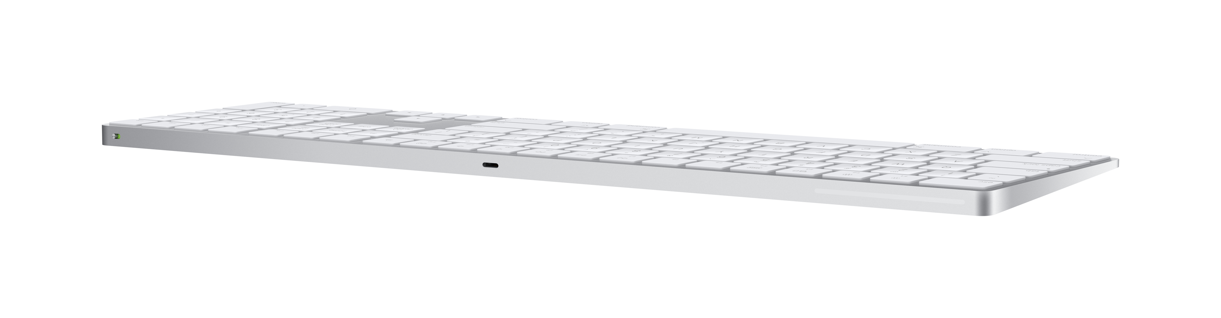 Un teclado plateado sobre una superficie blanca, visto de lado.