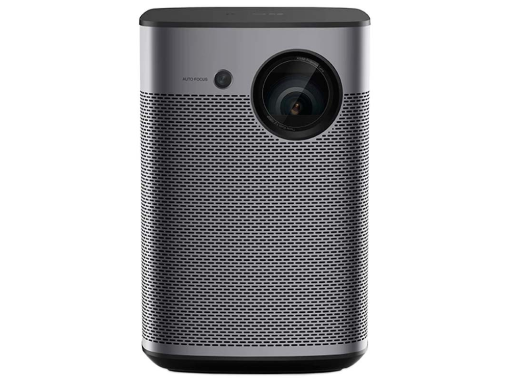 Proyector gris con lente, etiqueta de enfoque automático y superficie frontal perforada.