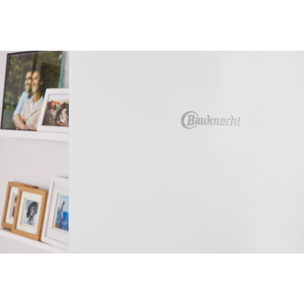 Eine weiße Wand mit einem Bauknecht-Logo und gerahmten Fotos auf einem weißen Regal.