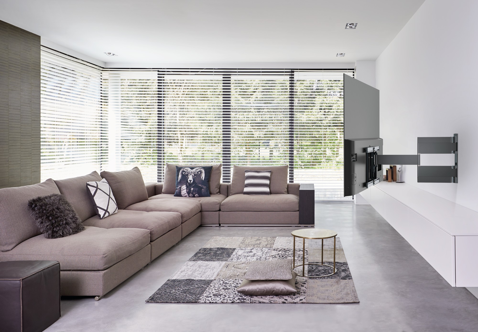Ein modernes Wohnzimmer mit großem Ecksofa, Teppich und Holz-Wanddekor.