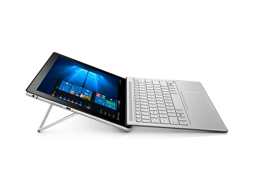 Ein silbernes Tablet mit integriertem Ständer und abnehmbarer Tastatur zeigt das Windows-Startmenü.