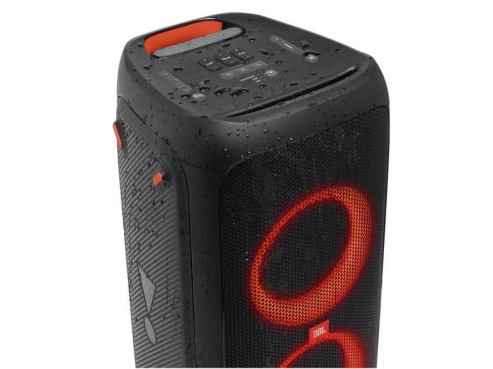Altavoz JBL negro con detalles naranjas, con círculos rojos brillantes y fondo negro.