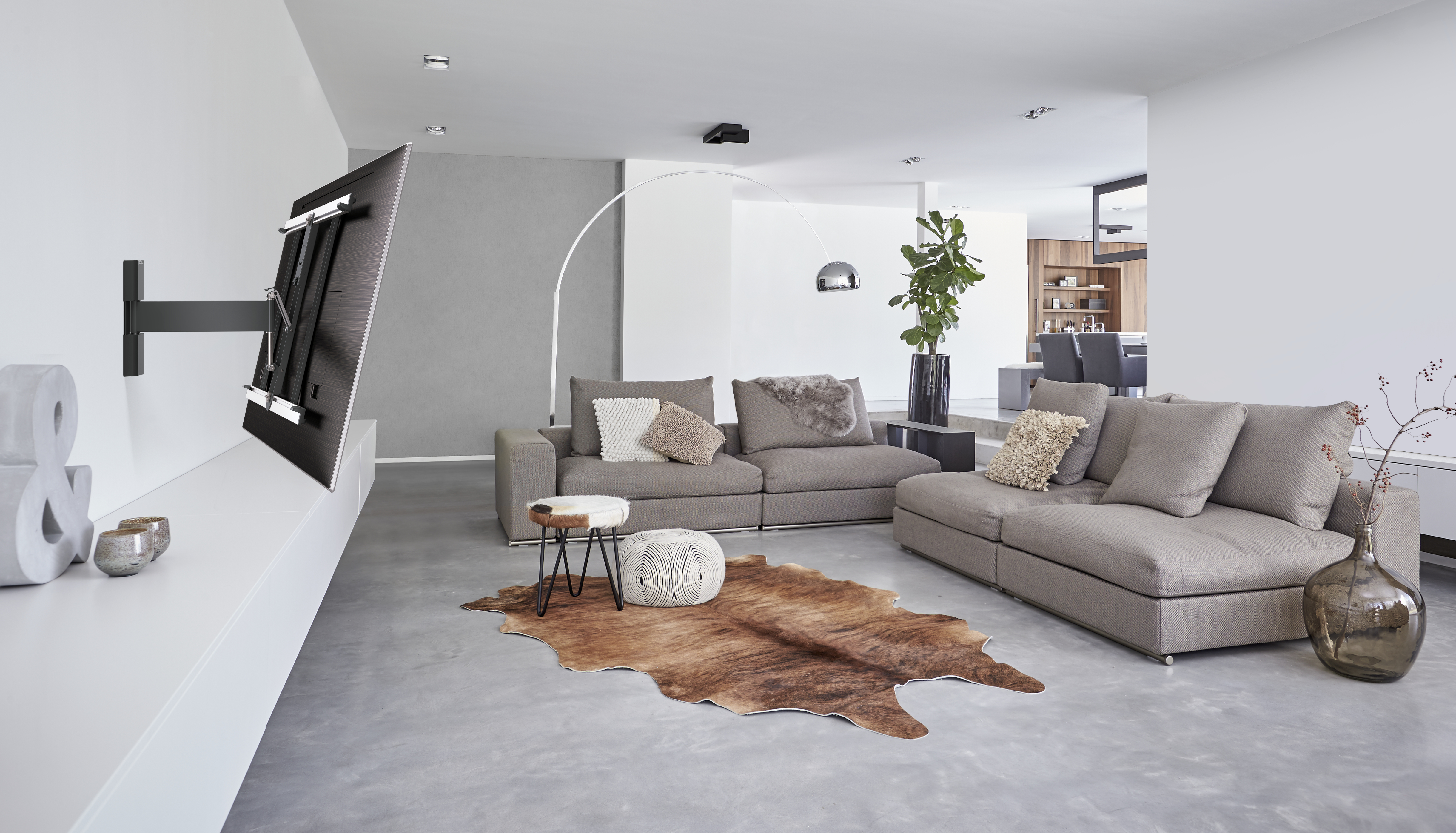 Ein Wohnzimmer mit an der Wand montiertem Fernseher.