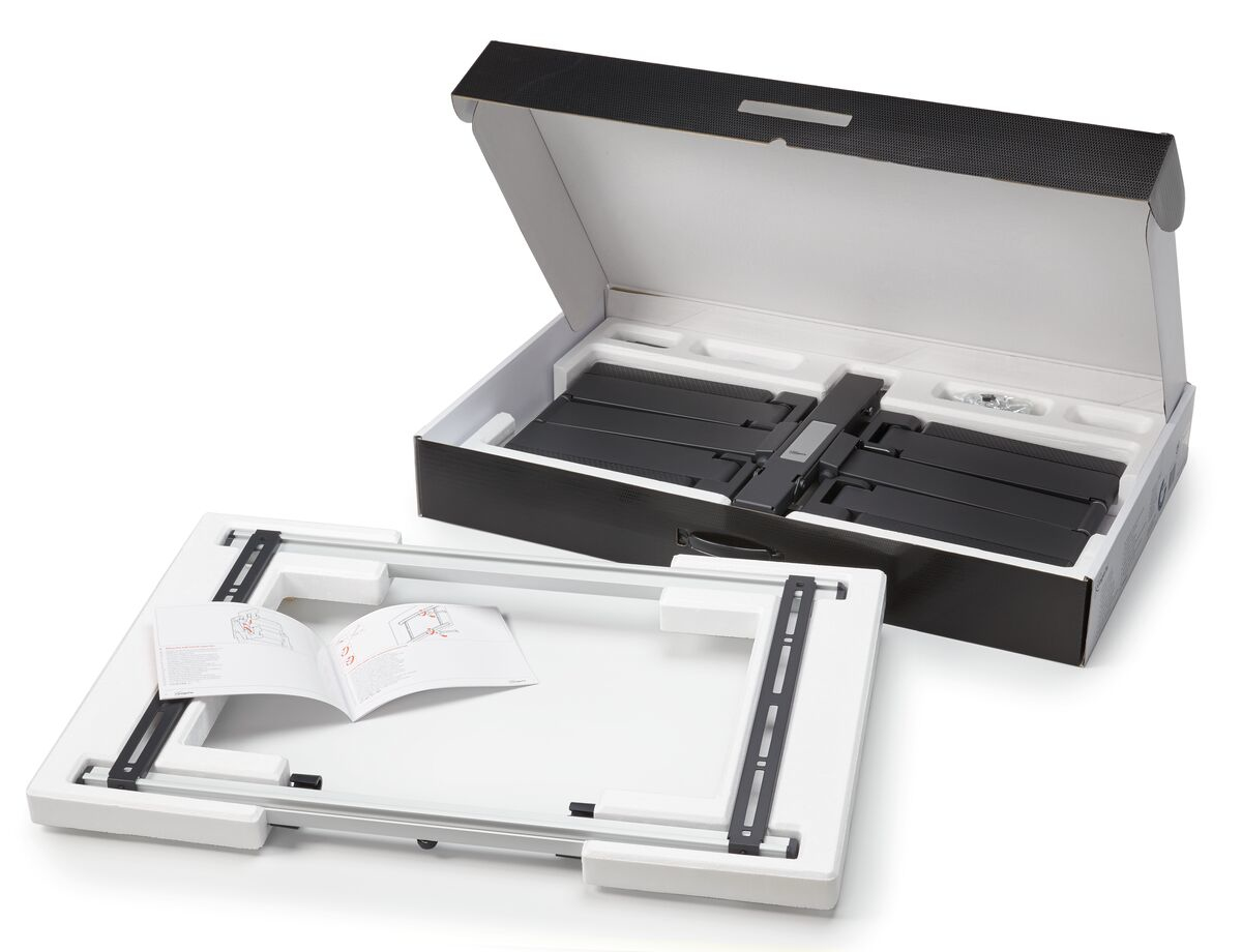 Eine schwarze Box mit gefalteten Gegenständen darin und eine separate weiße Schale mit einem Anleitungsheft.