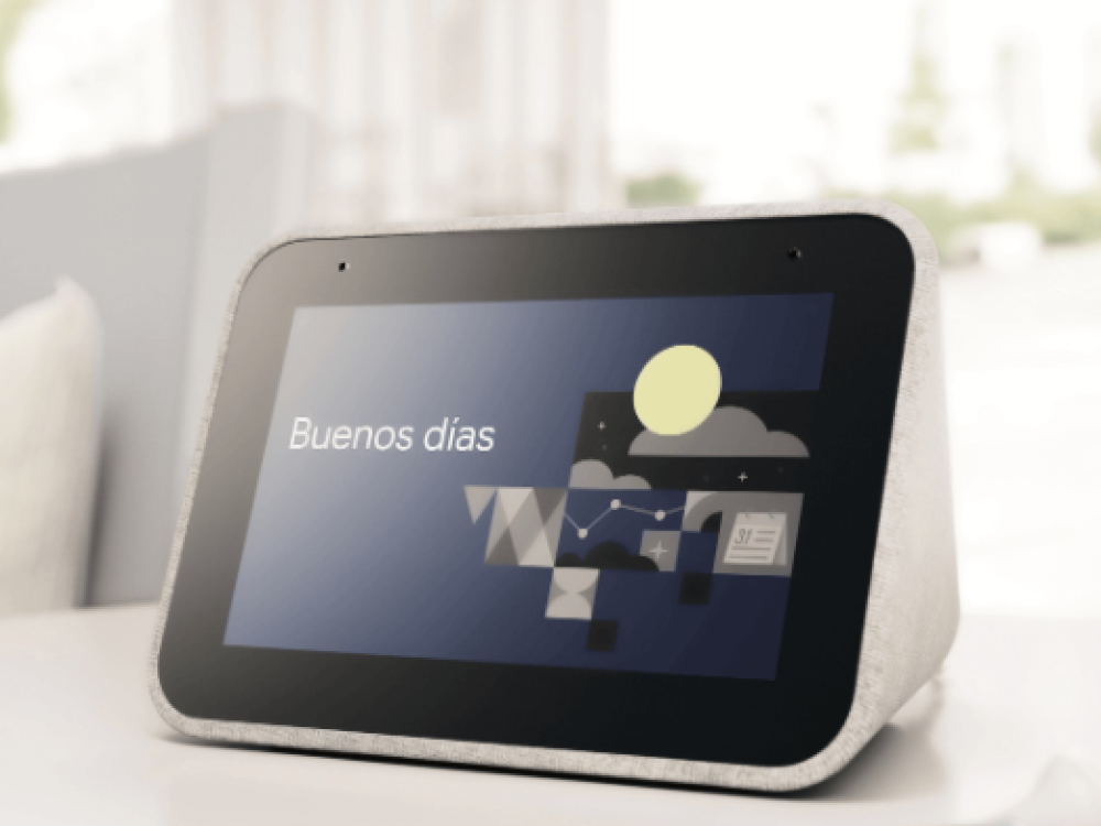 Una pantalla inteligente que muestra 'Buenos días', con un gráfico, sobre una mesa.
