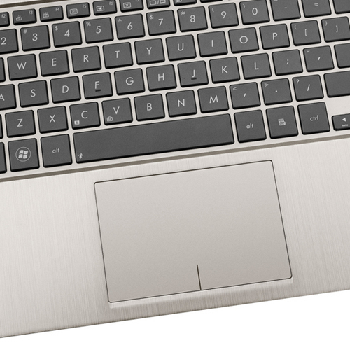 Nahaufnahme einer silbernen Laptop-Tastatur mit schwarzem Trackpad und gebürsteter Metalloberfläche.