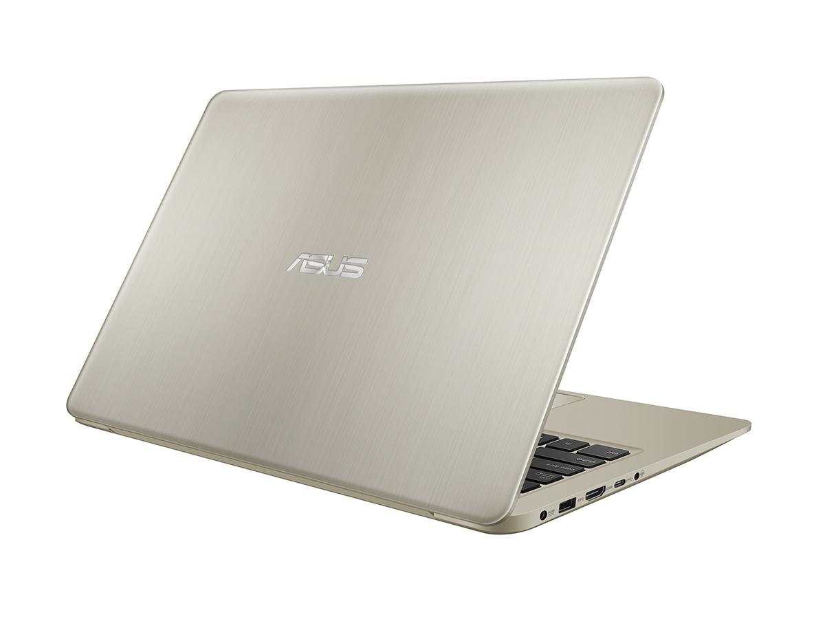Ein geschlossener silberner Asus Laptop steht schräg auf einer weißen Oberfläche mit sichtbaren Anschlüssen.