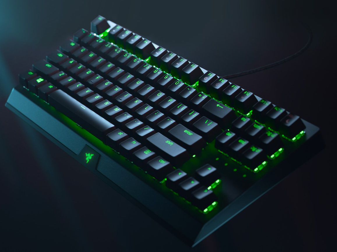 Schwarze Gaming-Tastatur mit grünen Lichtern. Razer-Logo ist sichtbar.