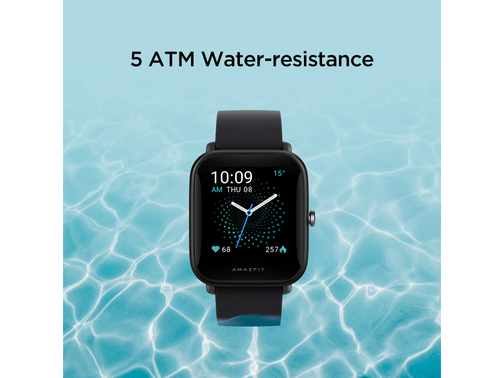 Reloj inteligente negro sobre superficie de agua. Muestra hora, ritmo cardíaco y métricas.