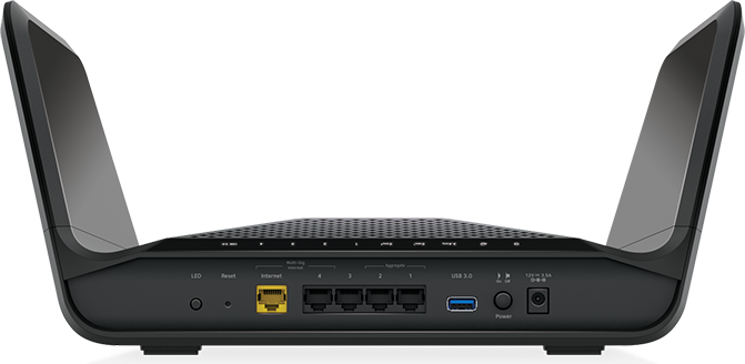 Schwarzer Router mit Antennen. Anschlüsse: Ethernet, USB und Strom. Steht auf einem Tisch.