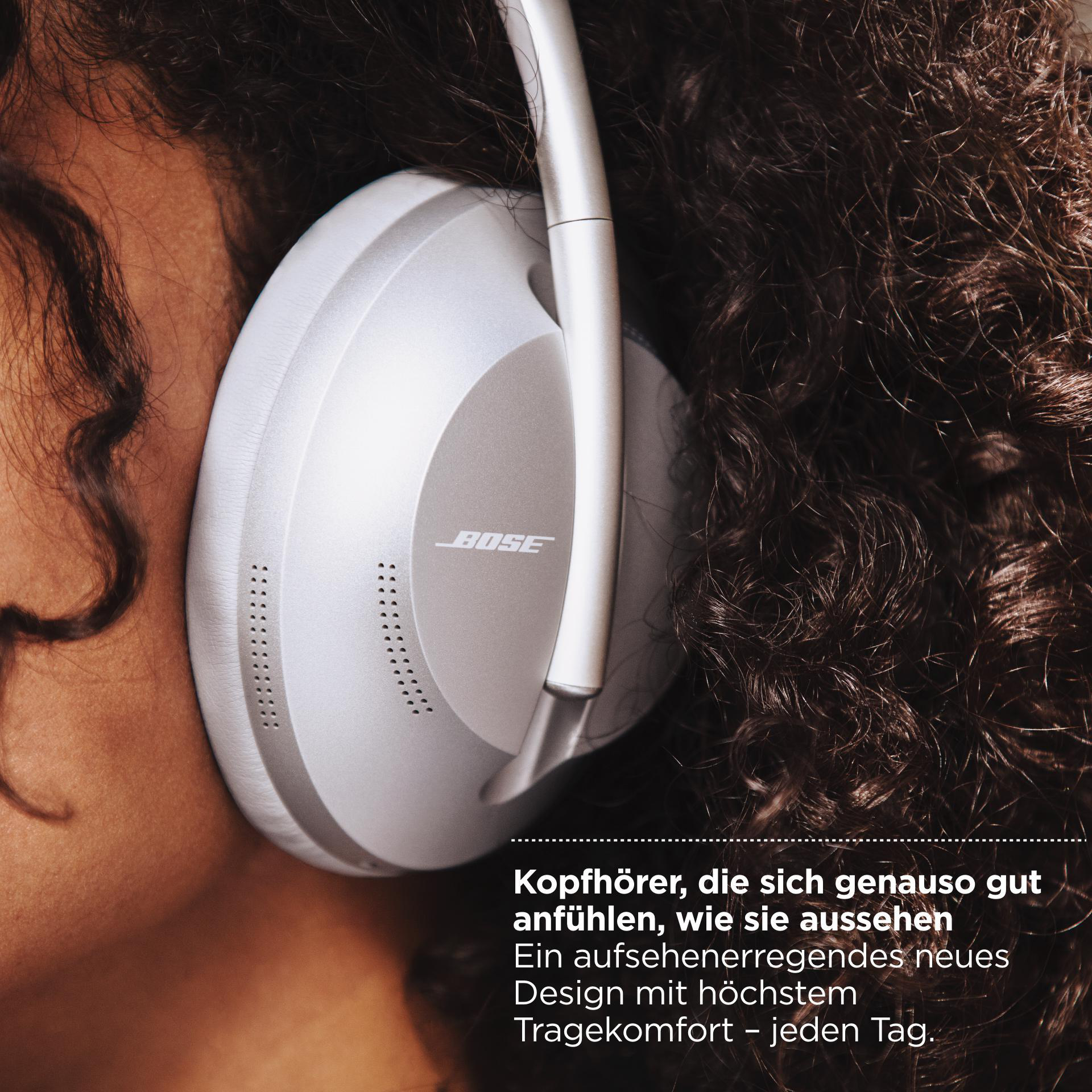 Frau mit silbernen Bose-Kopfhörern. Deutscher Text beschreibt die Kopfhörer.