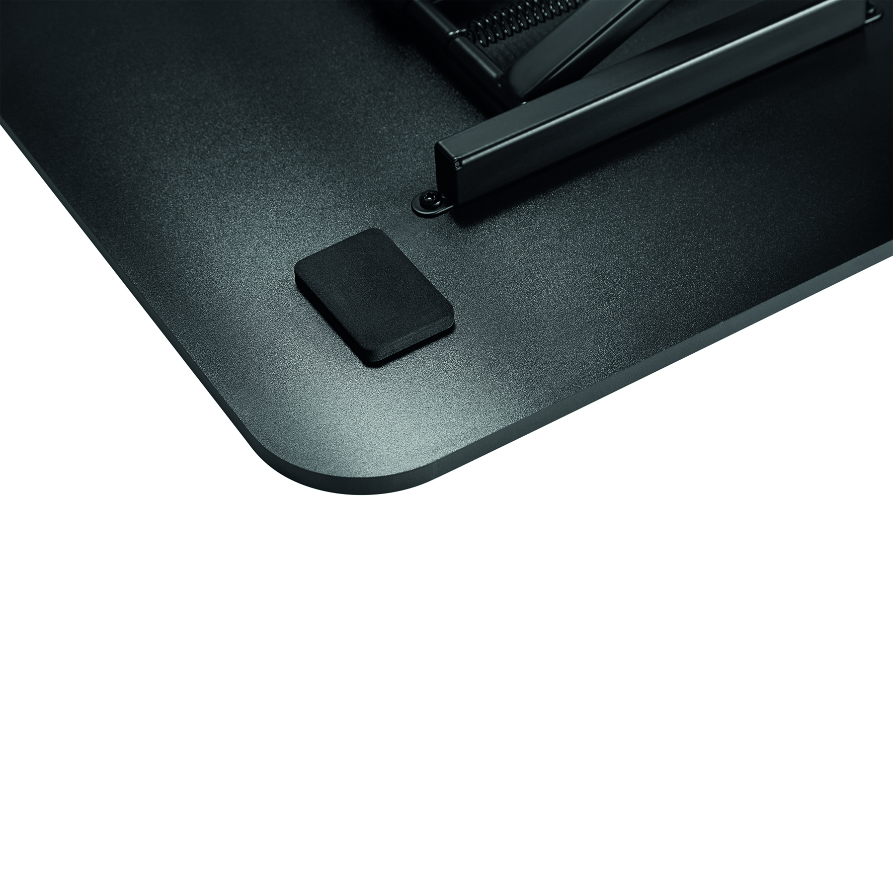 A desk corner with a black pad and a metal support.