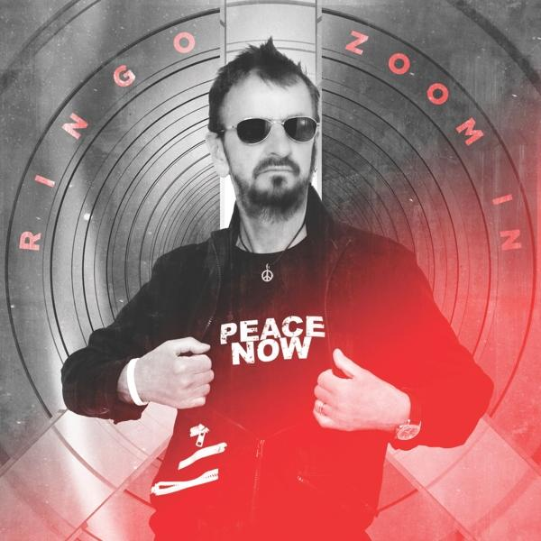 Ringo Starr met zonnebril en een zwart jasje, met "PEACE NOW" op zijn shirt.