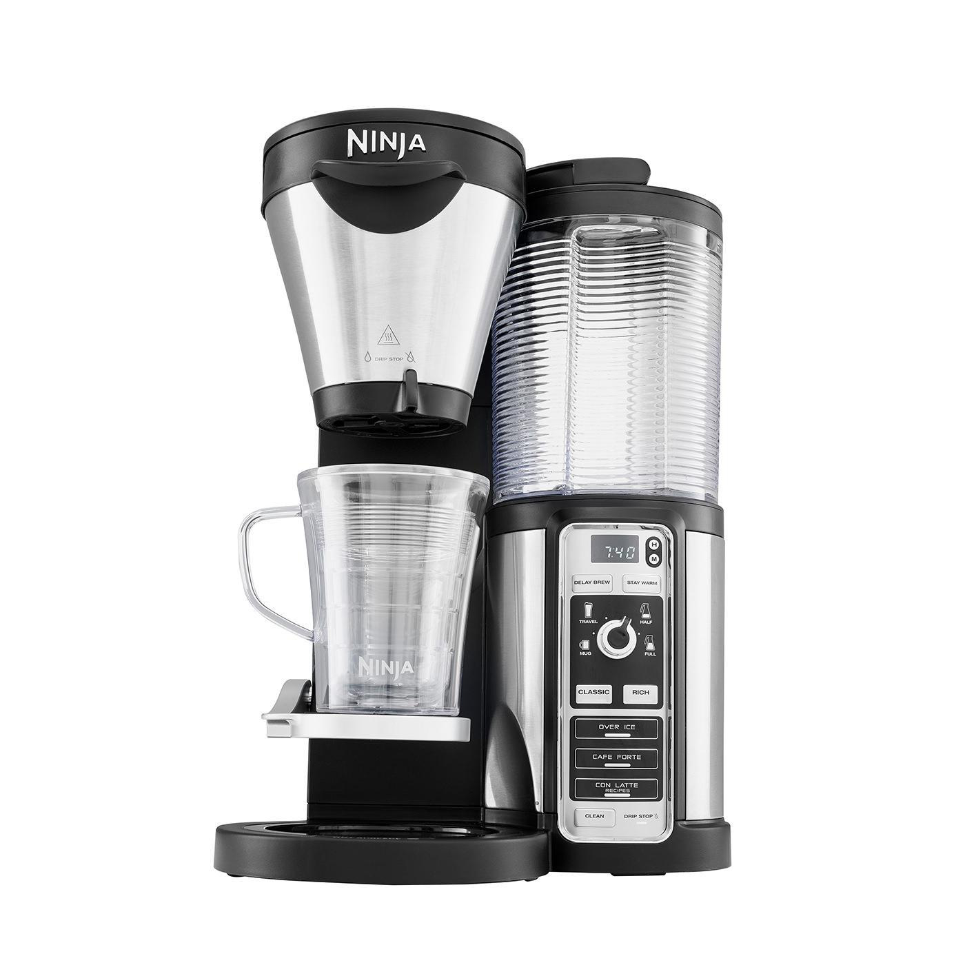 Ein silber-schwarzer Ninja-Kaffeeautomat mit transparentem Wasserbehälter und Glaskaraffe.