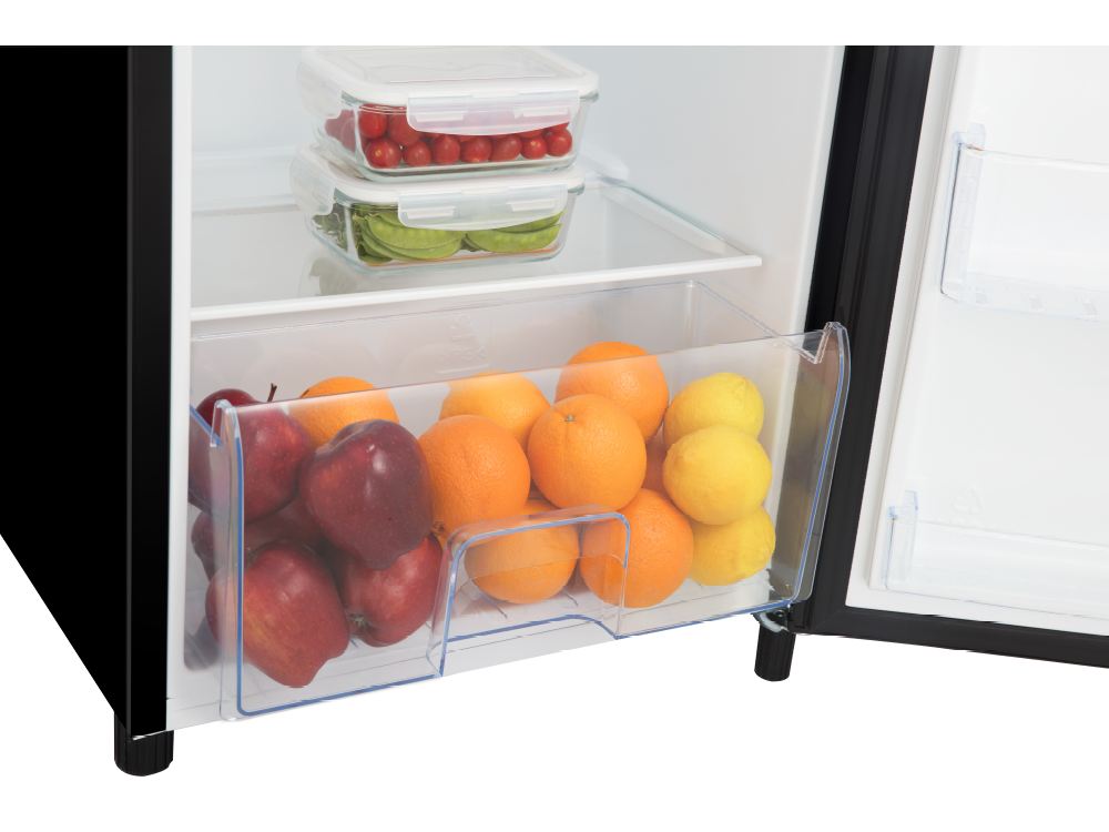 Primer plano del cajón del refrigerador lleno de manzanas, naranjas y limones.