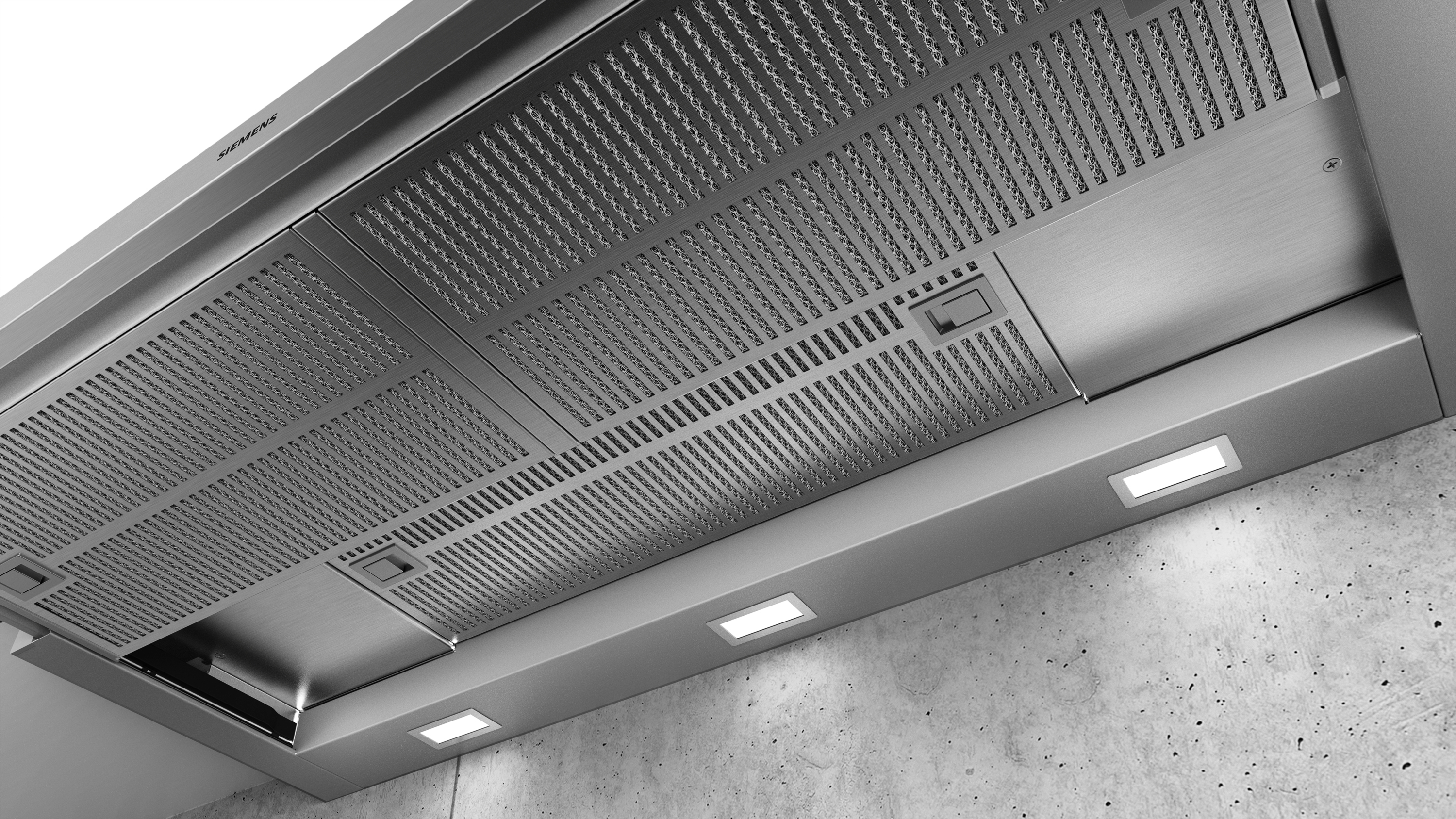 Hotte en acier inoxydable sur mur en béton gris, avec trois encastrés.