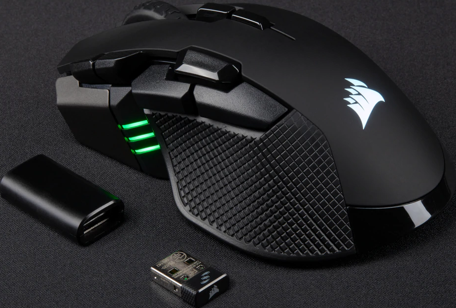 Eine schwarze Gaming-Maus mit schwarzem Akku und kleinem drahtlosem Empfänger auf schwarzer Oberfläche.