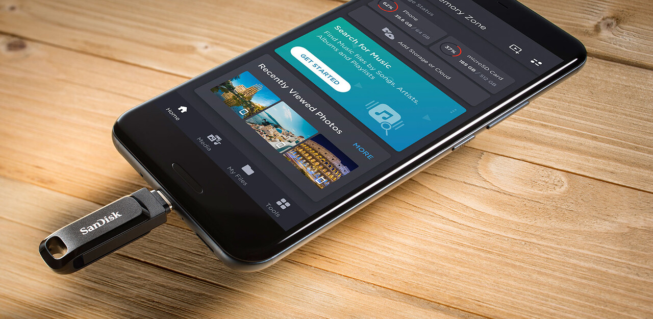 Un téléphone avec une clé USB SanDisk branchée. L'écran affiche une application de gestion de fichiers.