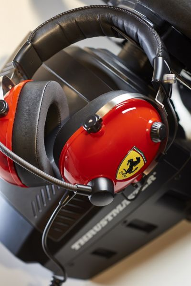 Casque Ferrari rouge avec détails noirs sur une configuration de simulation Thrustmaster.