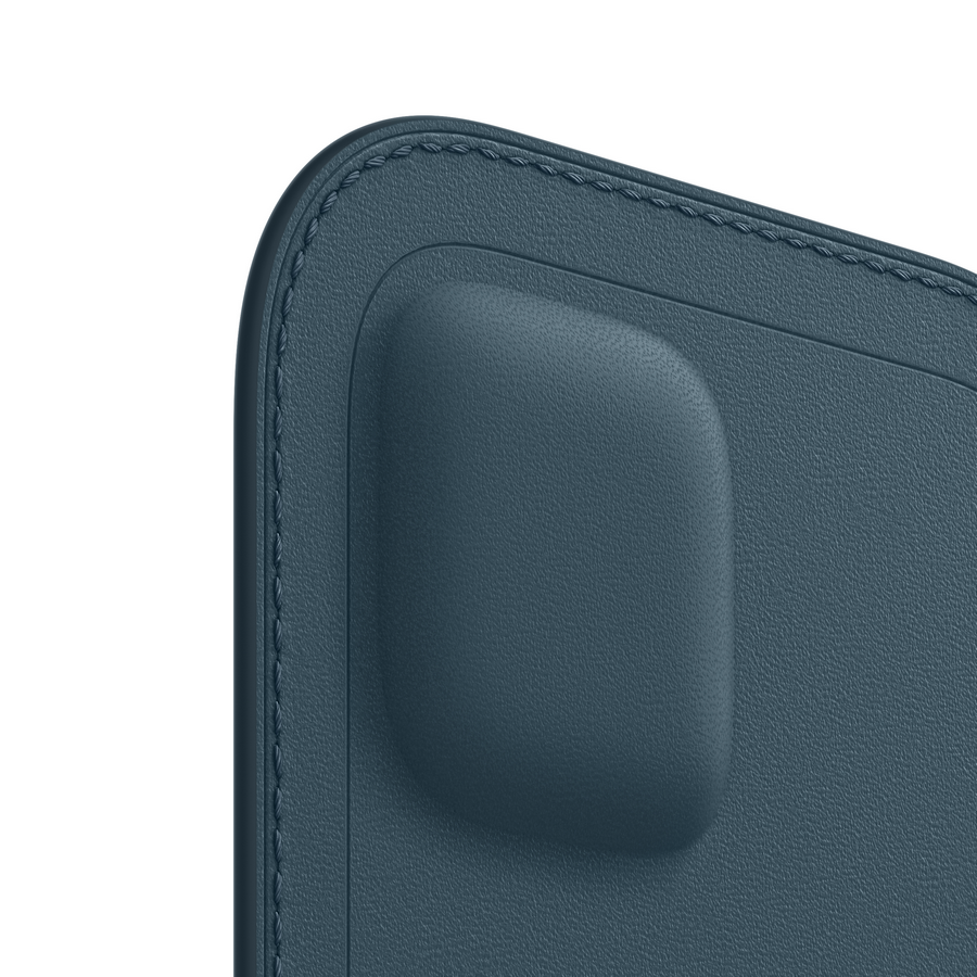 Primer plano de una esquina de funda magnética de cuero azul. Son visibles costuras y un cuadrado en relieve.