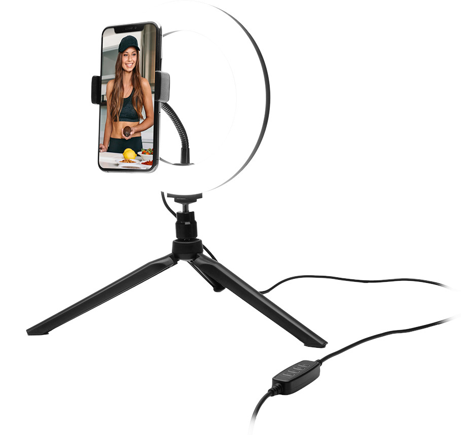 Vrouw die zichzelf filmt met een telefoon in een ringlamp.