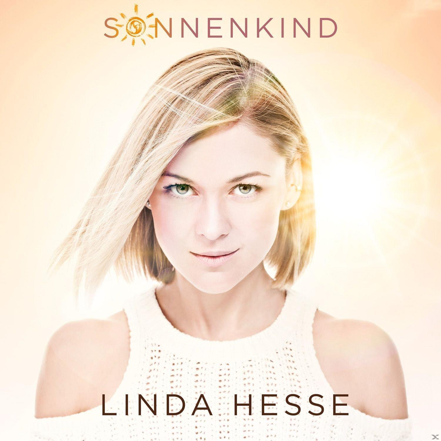 Eine Frau mit blonden Haaren und einem weißen Pullover. Der Text 'SONNENKIND' steht über ihrem Kopf und 'LINDA HESSE' darunter.