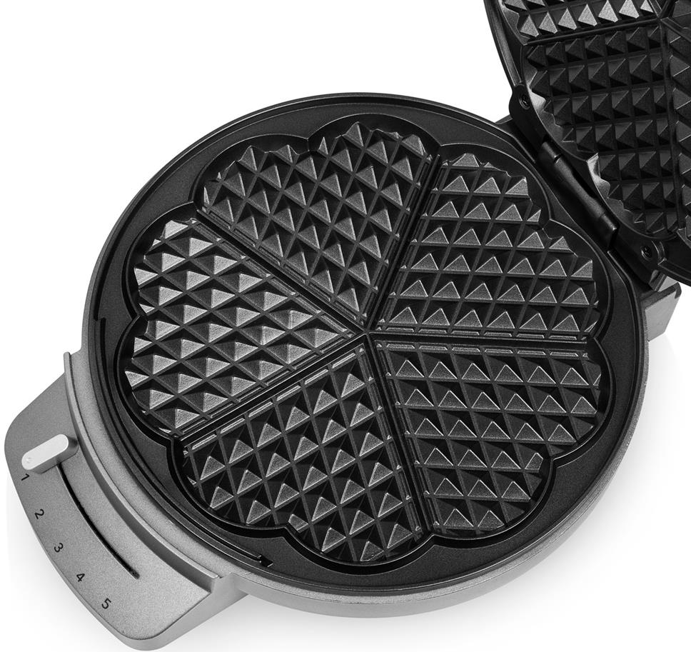 Macchina per waffle, aperta, che mostra stampi a forma di cuore. L'esterno è grigio.