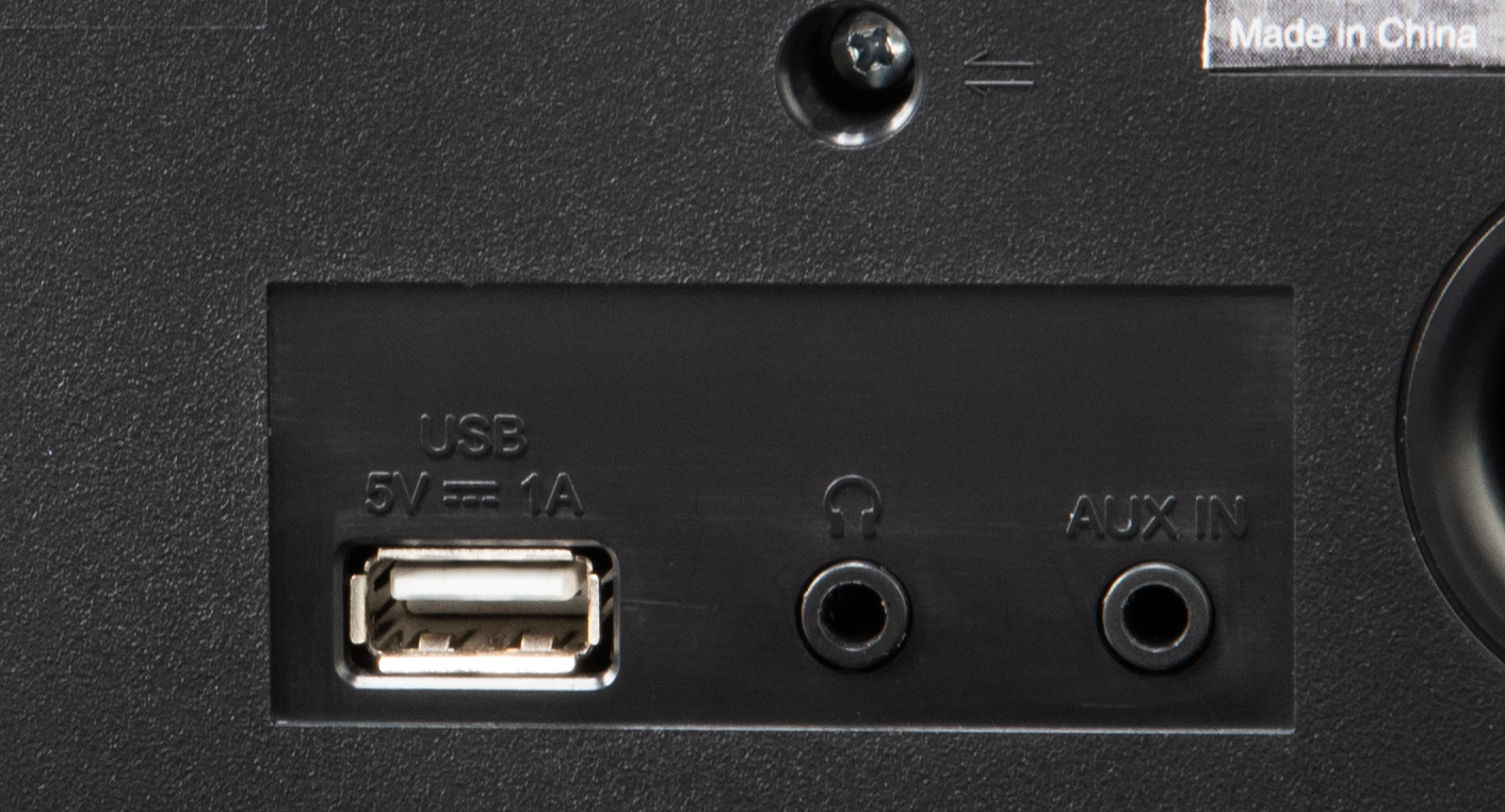 Gros plan sur un panneau noir avec ports USB, casque et aux-in. Fond blanc.
