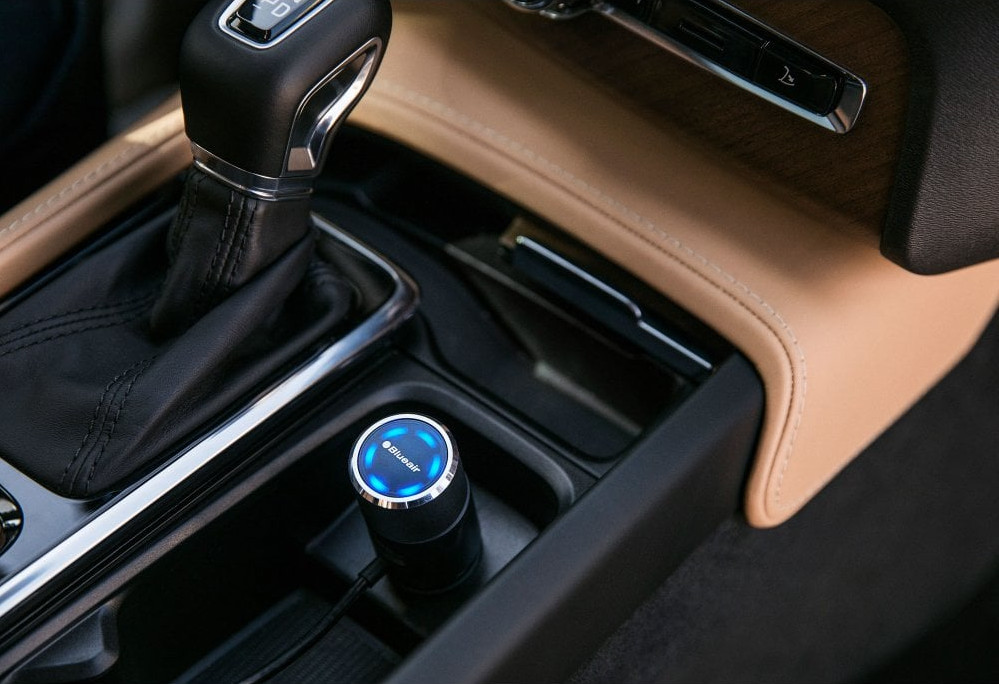 Blueair car air purifier in a car's center console.
