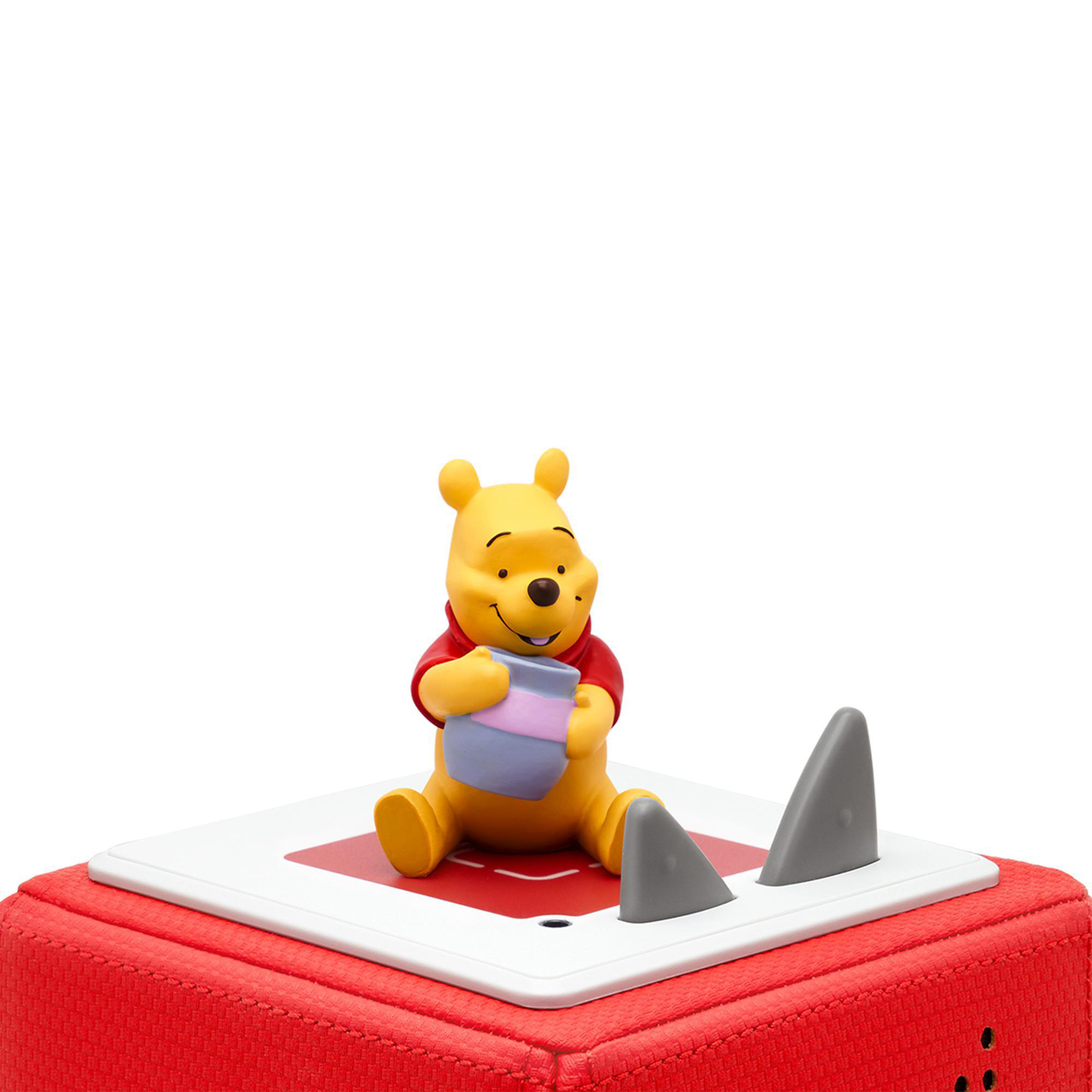 Winnie-the-Pooh-Figur sitzt auf roter Basis mit grauen Haifischflossen.