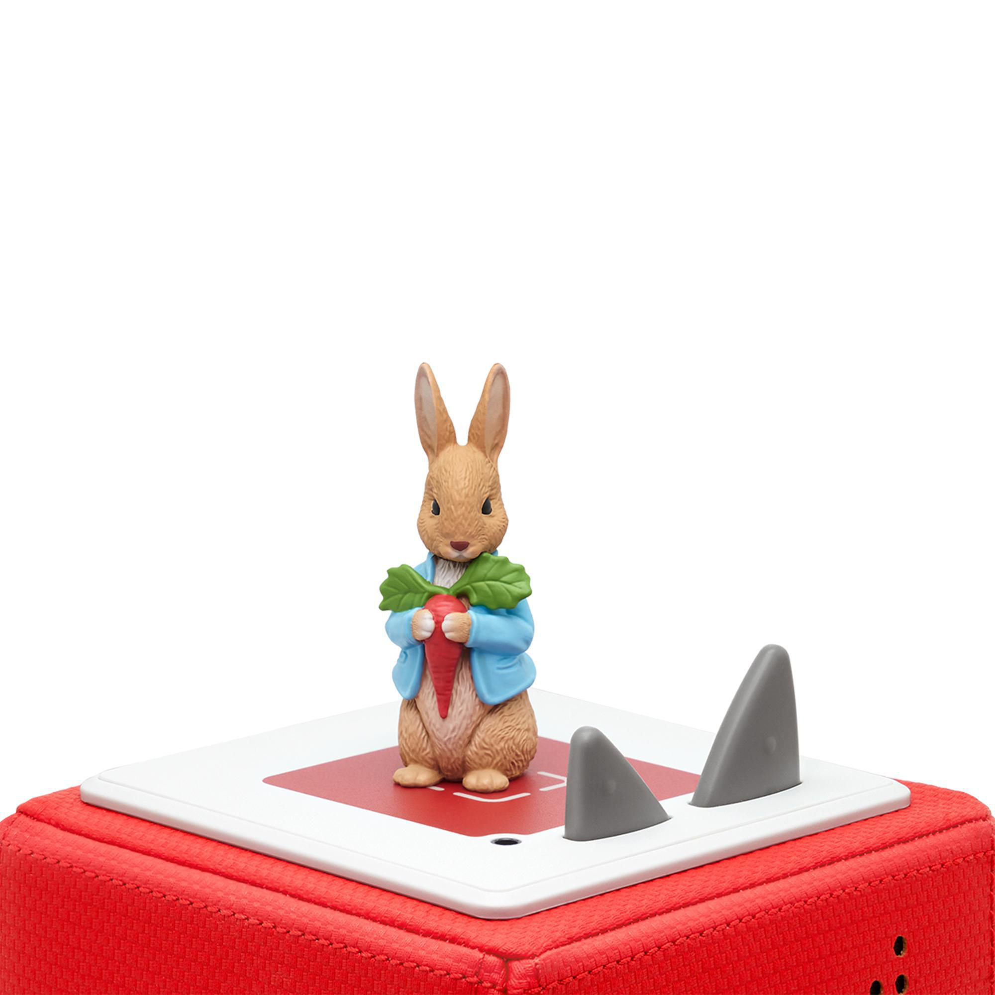 Peter Rabbit-Figur hält eine Karotte auf roter und weißer Basis mit zwei grauen Dreiecksformen.