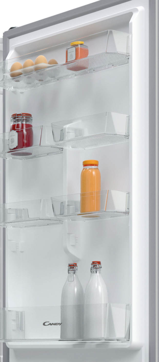 Dentro de un refrigerador blanco, se ven estantes con frascos, botellas y alimentos. La puerta está abierta.