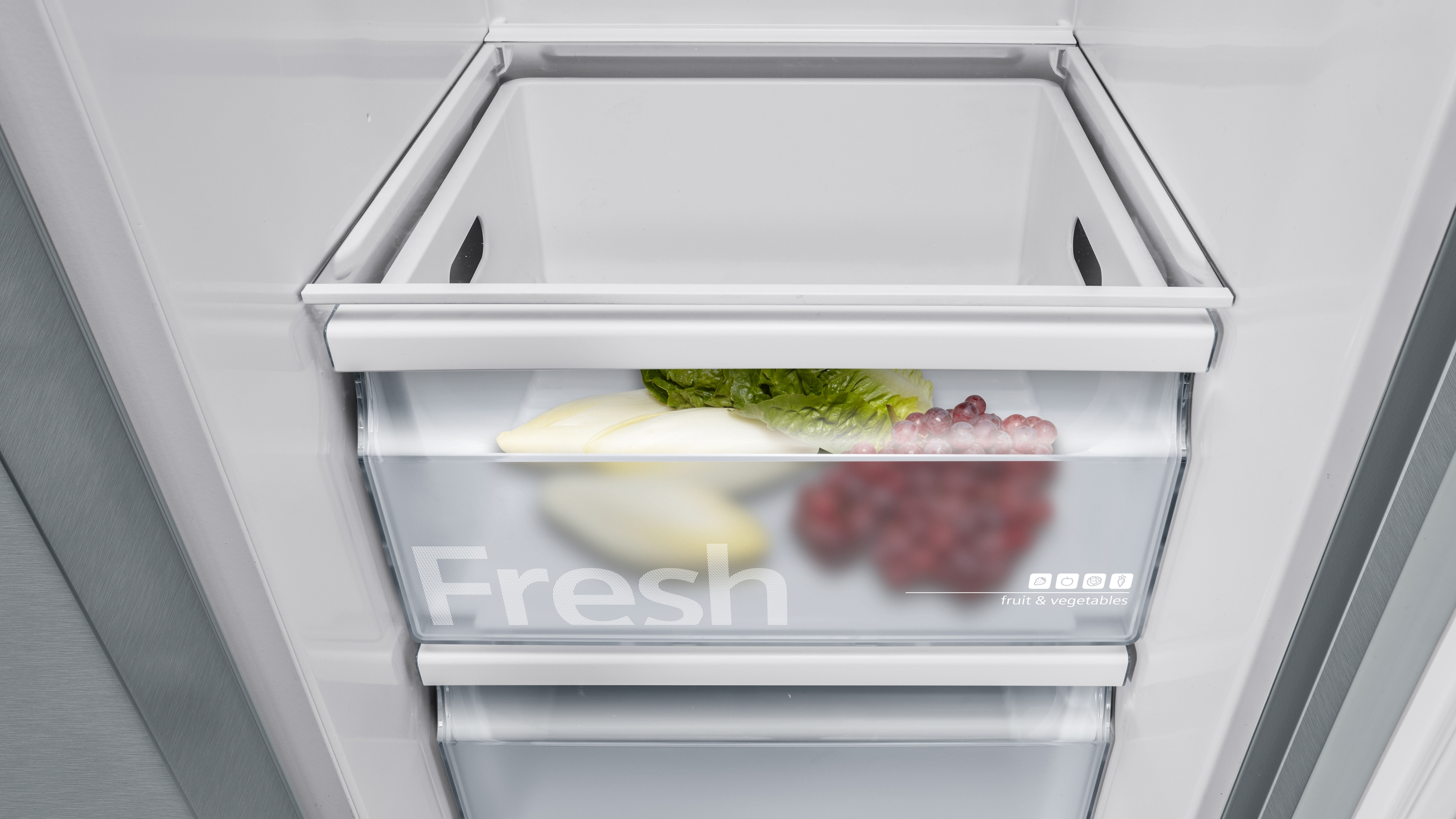 Kühlschublade mit Gemüse sichtbar.