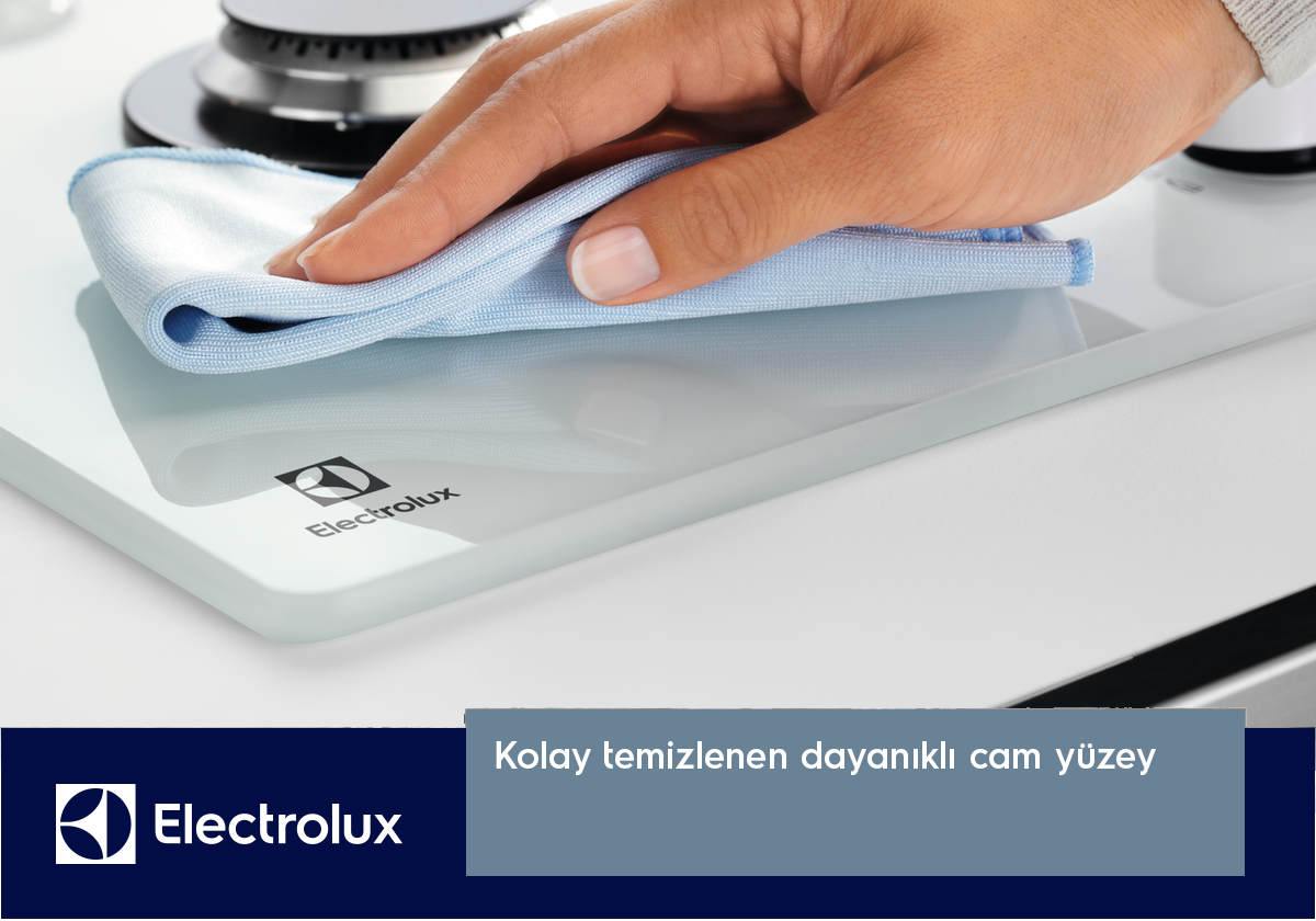 Bir el, mavi bir bezle beyaz cam yüzeyli ocağı temizliyor.
