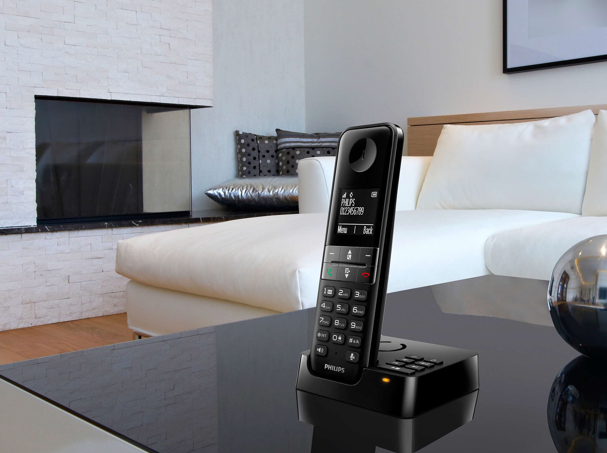 Un téléphone Philips sans fil sur une table avec une station de charge.