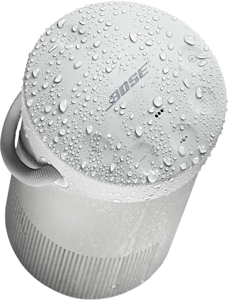 White, cylindrical Bose speaker covered in water droplets. Gray handle on top.