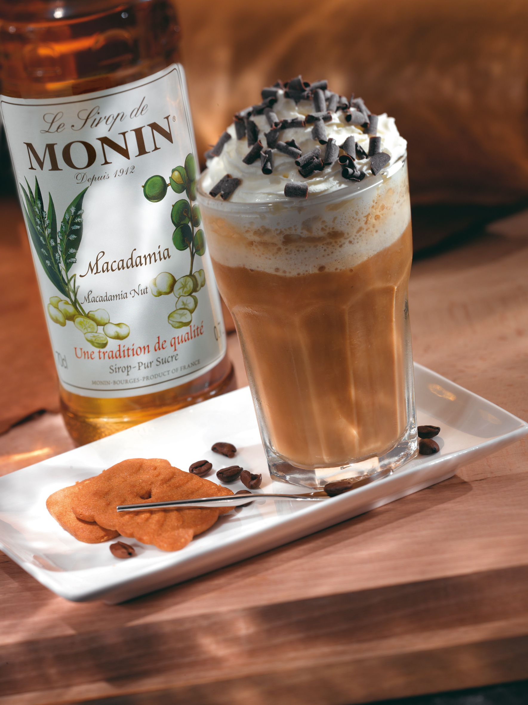 Macadamia-Nuss-Latte mit Schlagsahne und Schokoladenraspeln, Monin-Sirup und Keksen.