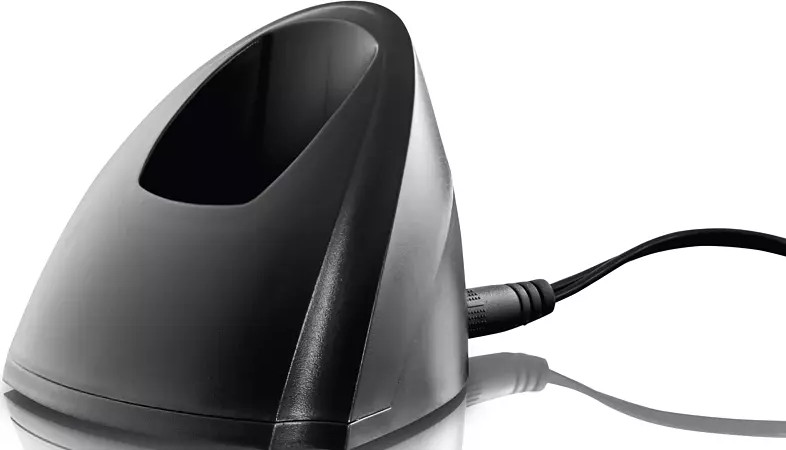 Base de chargement noire avec un câble branché. Elle a une forme incurvée. Fond blanc.