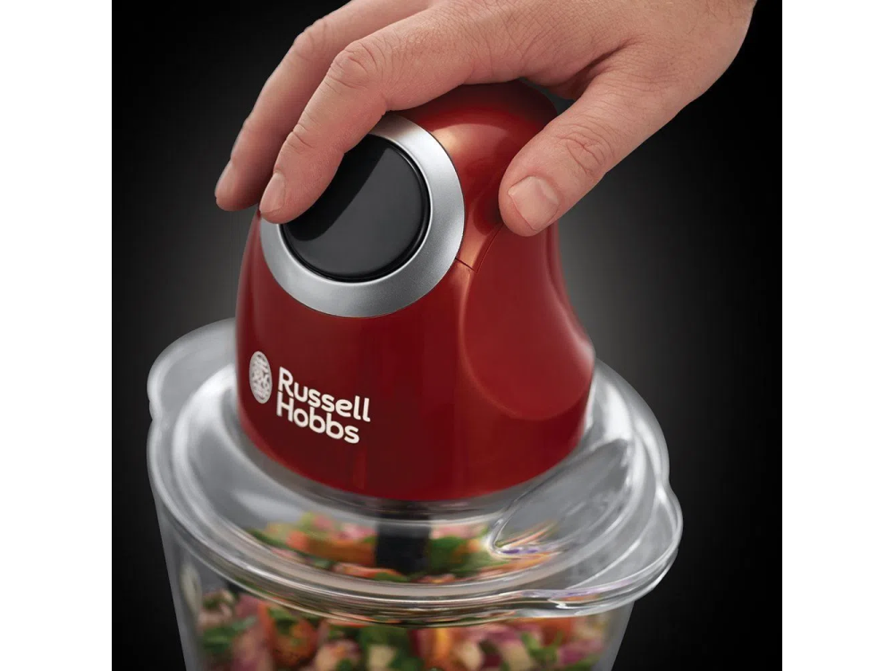 Un picador de alimentos rojo con una mano sosteniendo la parte superior.