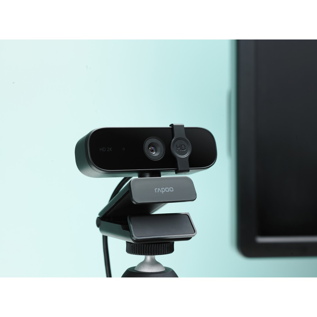 Webcam auf einem Stativ, schwarze Farbe. Die Kamera befindet sich vor blauem und schwarzem Hintergrund.