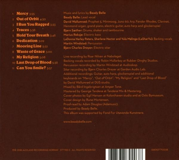 Albumcover mit Musiktitel-Liste und Credits auf braunem Hintergrund.