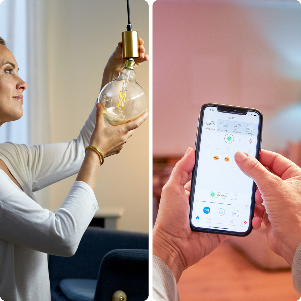 Vrouw met een gloeilamp en telefoon met smart home app. Gedempte verlichting, neutrale tinten.