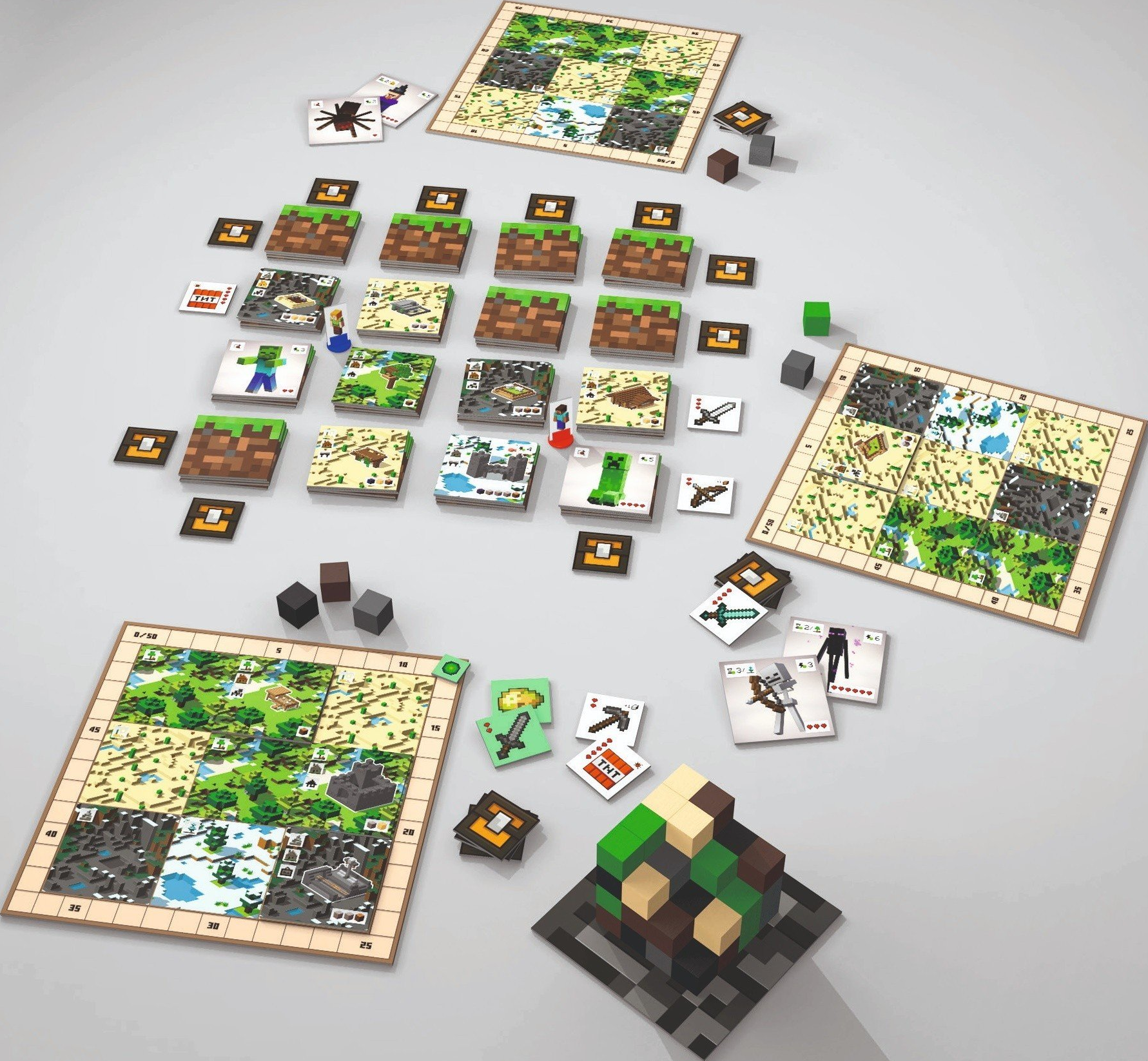 Ein Minecraft-Brettspiel-Setup. Spielbretter, Karten, Blöcke und Figuren sind auf einer hellgrauen Oberfläche angeordnet.