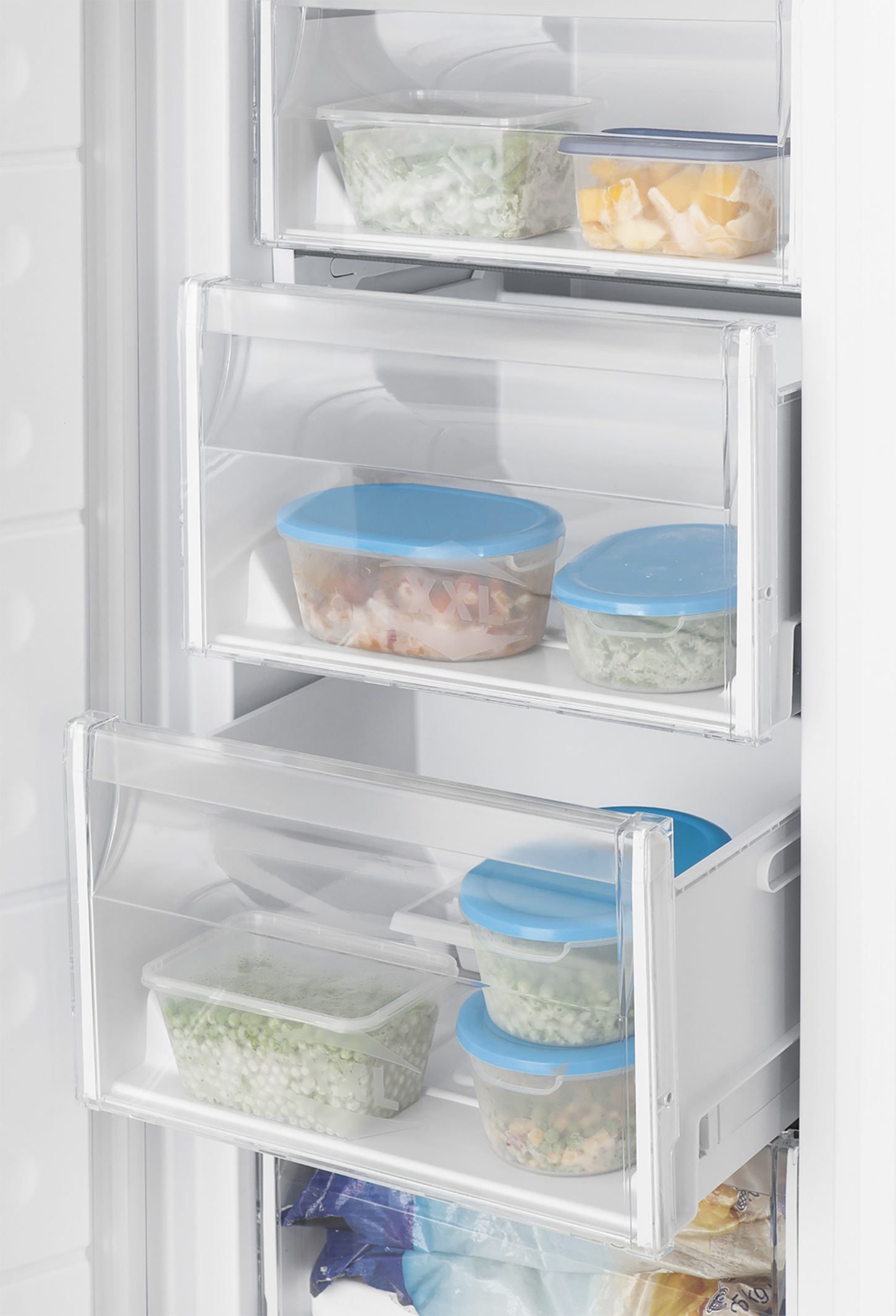 A close-up of a refrigerator interior with drawers filled with frozen food.