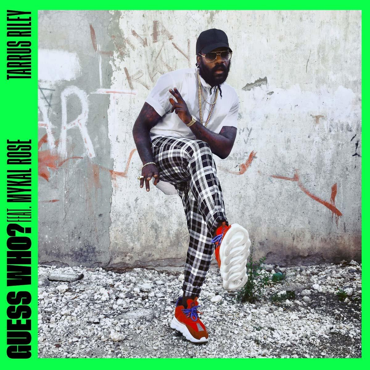 Albumcover mit einem Mann in karierten Hosen und einem weißen Hemd, mit Graffiti-Hintergrund.