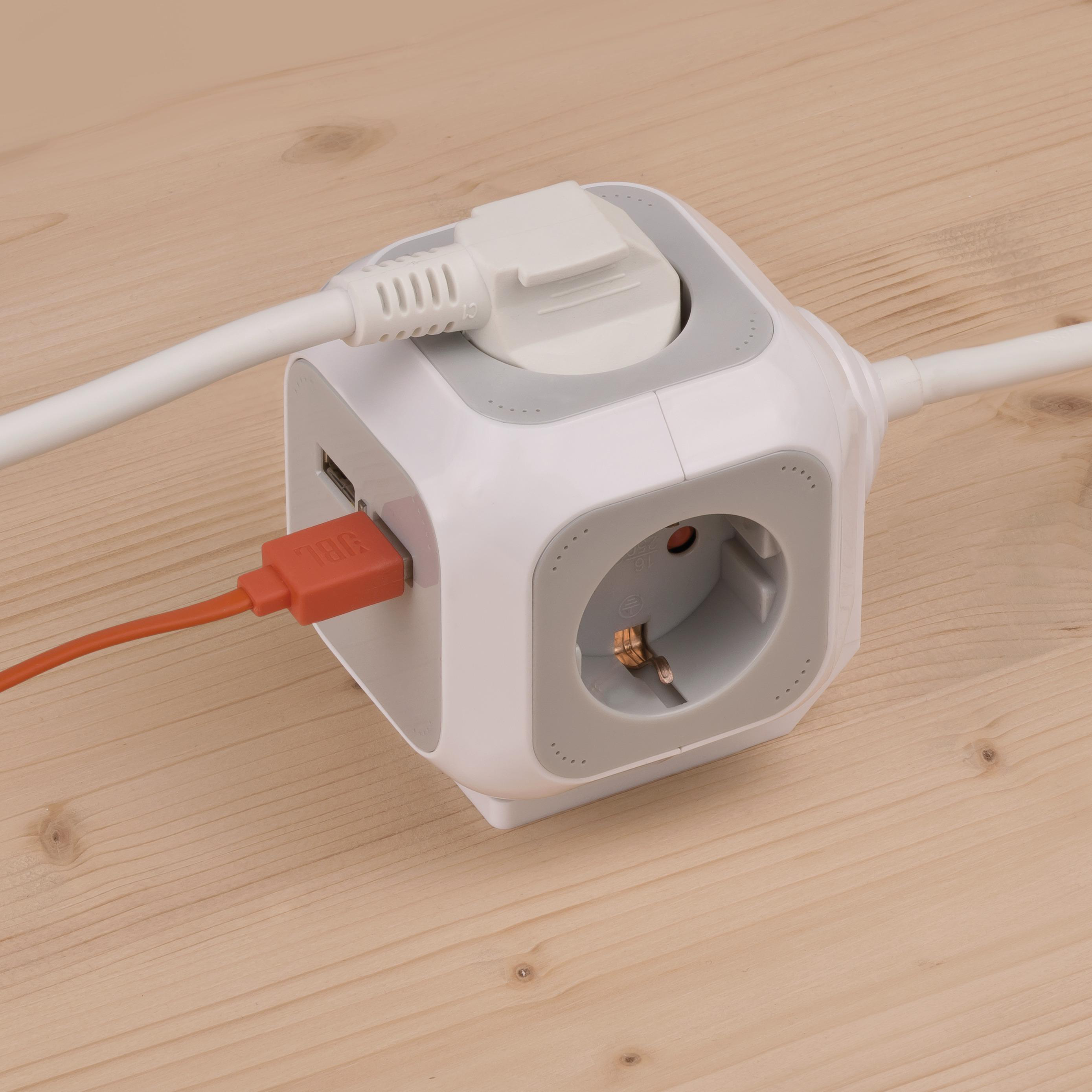 Eine würfelförmige Steckdose mit weiß-grauem Design und einem roten USB-Kabel.