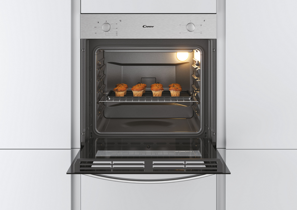 Un horno con puerta abierta y magdalenas en la rejilla. Horno Candy con exterior blanco.